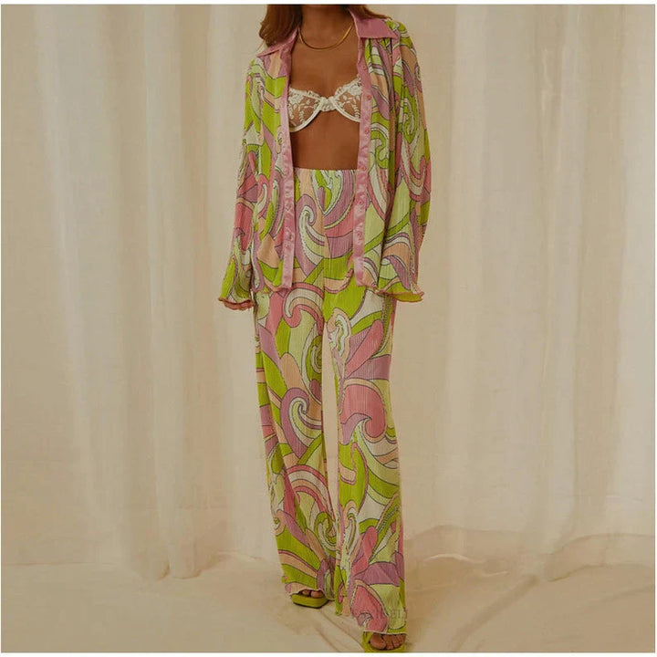 Pyjama féminin léger et confortable avec un design coloré et rétro. Le haut à manches longues et le pantalon fluide sont ornés de motifs abstraits dans des tons de rose, vert et violet. Le pyjama est élégant et parfait pour une tenue décontractée et stylée.