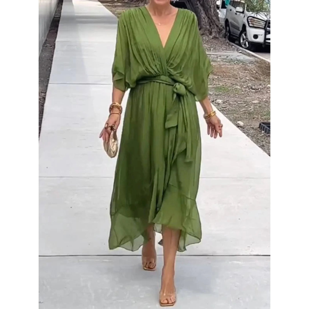Vert olive fluide, décolleté cache-cœur, manches amples et ceinture nouée à la taille, longueur midi avec ourlet volanté, en promenade.
