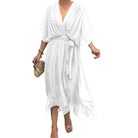 Blanche fluide, décolleté cache-cœur, manches amples et ceinture nouée à la taille, longueur midi avec ourlet volanté, en promenade.