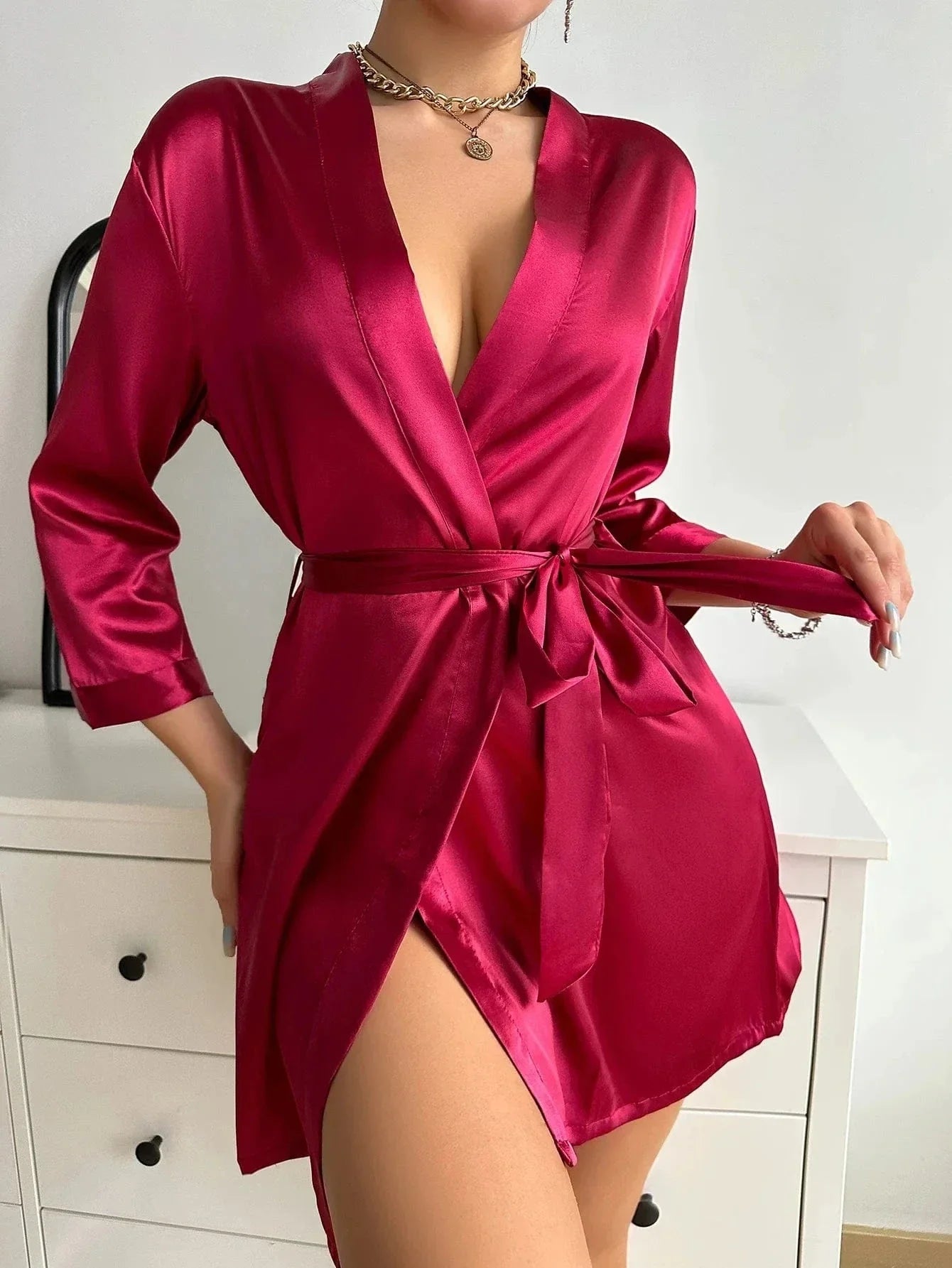 Kimono satin rouge pour femme, modèle, avec une coupe élégante et fluide. Ce kimono à manches longues et ceinture à la taille offre un confort optimal et un style raffiné, parfait pour une soirée chic ou un moment de détente.