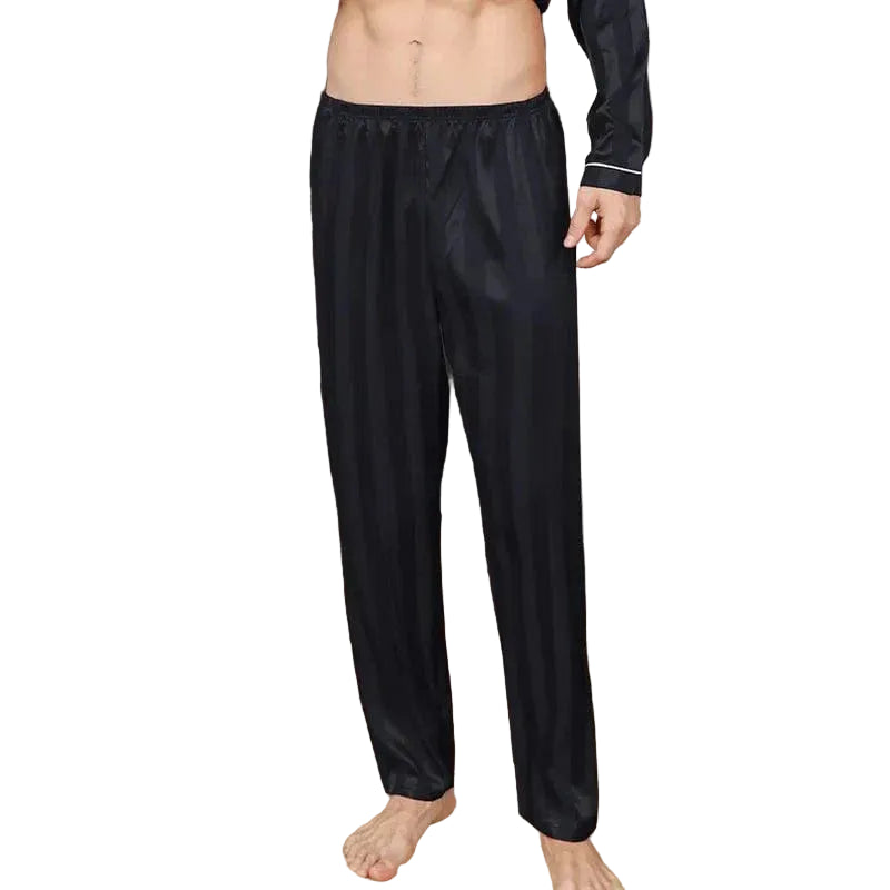 Vue de face d’un homme portant le pantalon de pyjama en satin pour homme Amaury, pantalon noir à fines rayures avec taille élastique confortable, coupe droite et tissu satiné doux offrant une sensation légère, élégante et agréable pour le sommeil ou la détente à la maison.