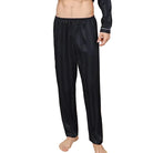 Vue de face d’un homme portant le pantalon de pyjama en satin pour homme Amaury, pantalon noir à fines rayures avec taille élastique confortable, coupe droite et tissu satiné doux offrant une sensation légère, élégante et agréable pour le sommeil ou la détente à la maison.