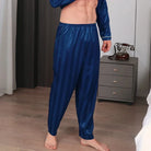 Vue de face d’un homme portant le pantalon de pyjama en satin pour homme Amaury, pantalon bleu marine satiné à fines rayures avec taille élastique confortable, coupe fluide et tissu doux offrant une sensation légère, élégante et agréable pour le repos et les moments de détente à la maison.