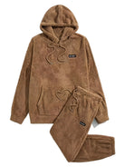 Pyjama teddy pour homme en polaire marron, composé d’un sweat à capuche avec poche kangourou et cordon de serrage, accompagné d’un pantalon assorti à taille élastique. Inscription “So what !” brodée sur la poitrine et la cuisse. Ensemble doux, chaud et ultra confortable, parfait pour l’hiver et le cocooning à la maison.