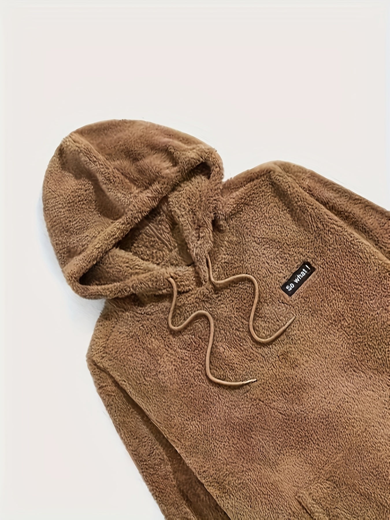 Haut de pyjama teddy pour homme en polaire marron, avec capuche et cordon assorti. Étiquette brodée sur la poitrine. Tissu doux et épais, parfait pour rester au chaud tout en profitant d’un confort optimal à la maison.