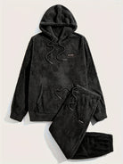 Pyjama teddy noir pour homme composé d’un haut à capuche avec cordon et d’un pantalon assorti, tous deux en tissu polaire doux et chaud. Inscription “So what !” brodée sur la poitrine et la cuisse. Ensemble confortable, parfait pour l’hiver et les moments de détente à la maison.