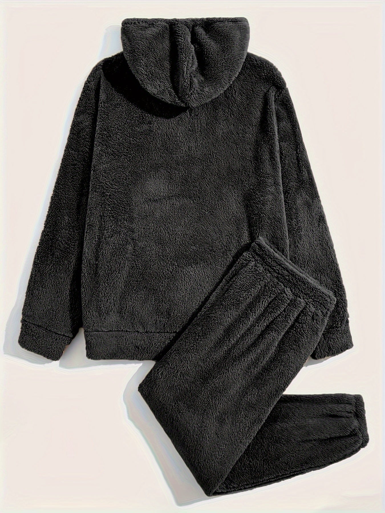 Ensemble pyjama teddy noir pour homme, composé d’un haut à capuche à manches longues et d’un pantalon assorti à taille élastique. Tissu polaire épais et doux, offrant un confort maximal et une chaleur idéale pour les soirées et nuits d’hiver.