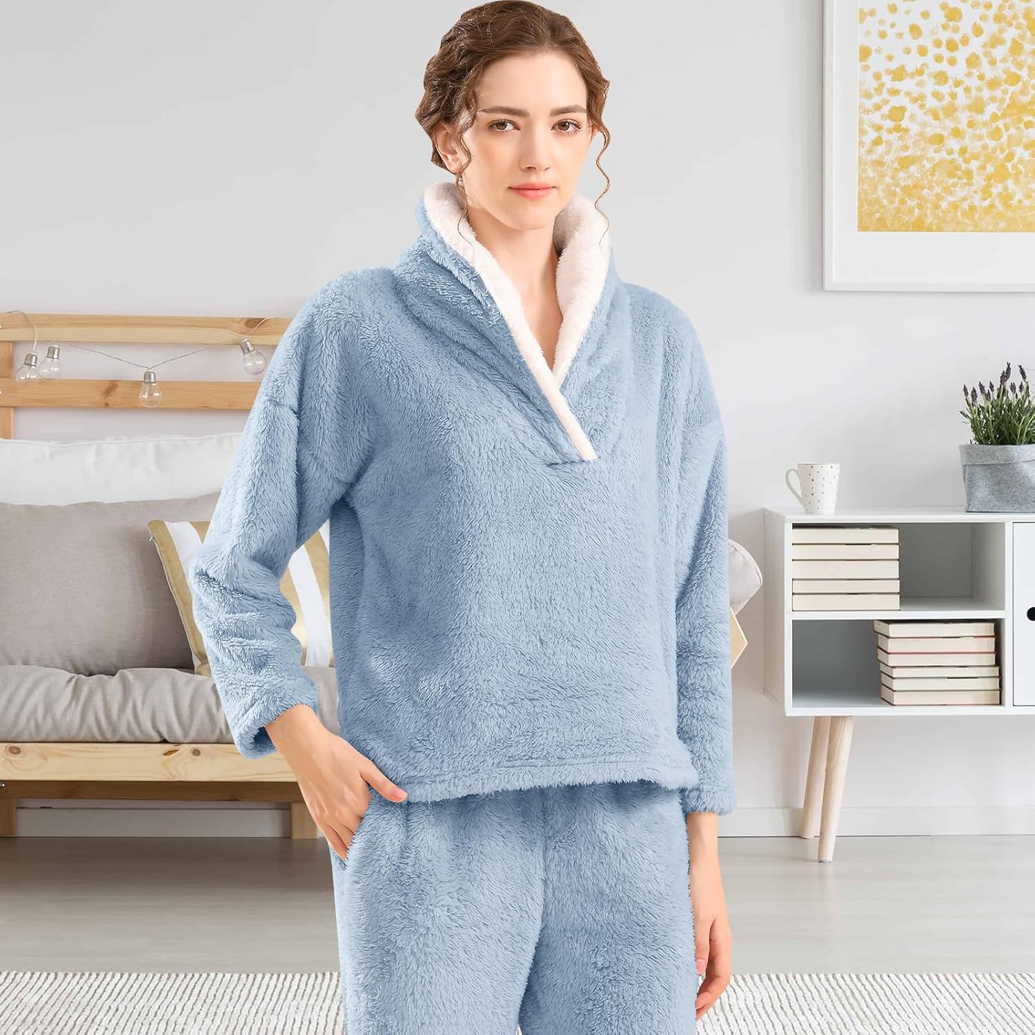Femme portant un pyjama polaire bleu ciel composé d’un haut doux à col large doublé en sherpa blanc et d’un pantalon assorti. Ensemble chaud, confortable et idéal pour l’hiver ou les moments cocooning à la maison.