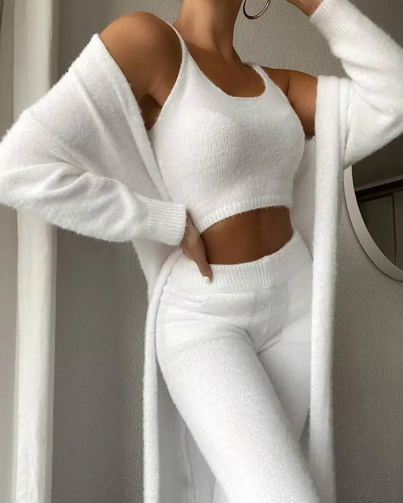 Ensemble Apolline pour femme en tricot blanc, composé d’un long gilet, d’un top court et d’un pantalon doux et confortable, parfait pour un look cosy et élégant à la maison.