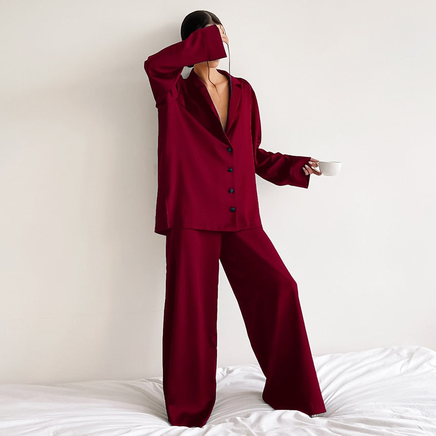 Pyjama femme Armelle bordeaux, ensemble deux pièces raffiné et confortable avec chemise fluide boutonnée à col tailleur et manches longues, pantalon large assorti, porté debout en intérieur, tissu satiné élégant.