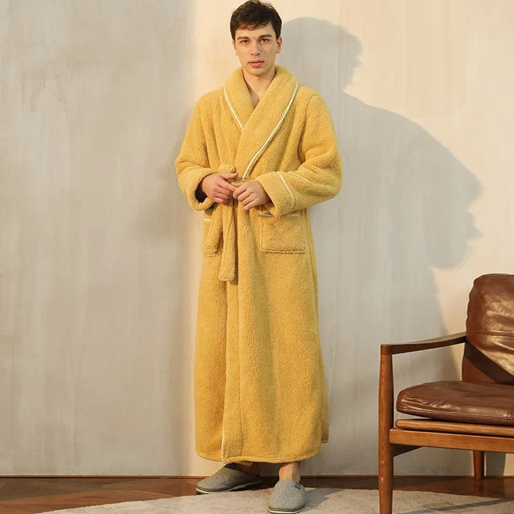 un peignoir long en tissu peluche ultra-doux de couleur jaune moutarde, avec ceinture, poches avant et finitions élégantes, idéal pour offrir chaleur et confort pendant la saison froide.