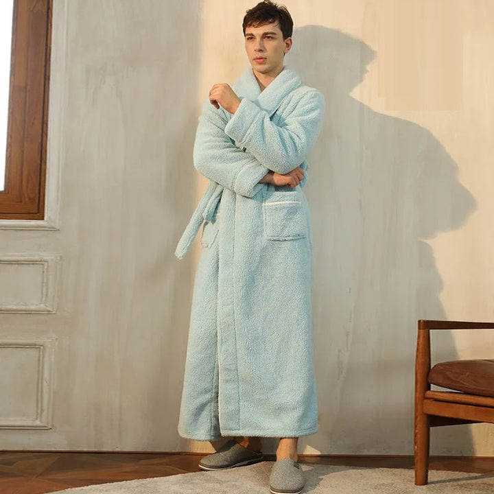un long peignoir bleu pastel en tissu peluche ultra doux avec ceinture et poches avant, offrant chaleur et confort idéal pour la saison hivernale.