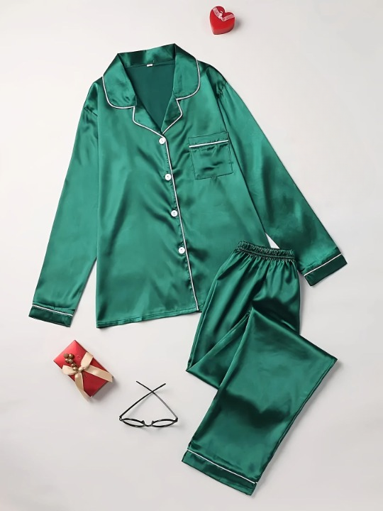 Pyjama deux pièces pour femme en satin vert émeraude, composé d’une chemise boutonnée à manches longues avec col à revers et passepoils blancs, accompagné d’un pantalon assorti à taille élastique. Ensemble élégant et confortable, parfait pour offrir ou se détendre avec style.