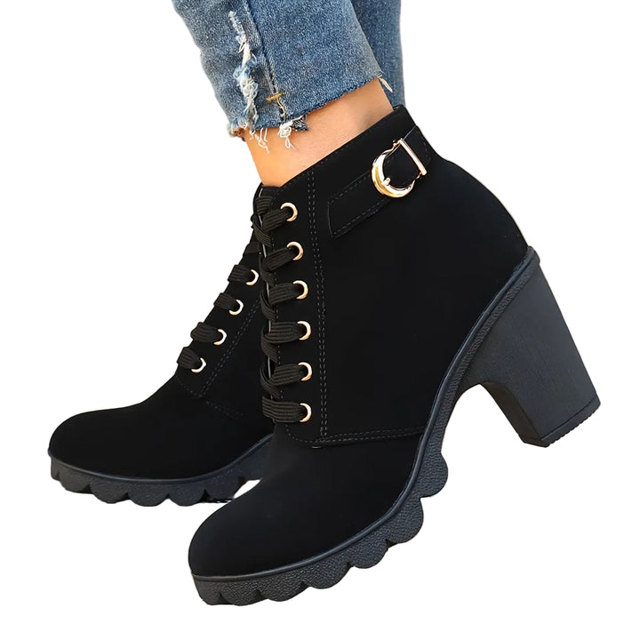 Bottines noires à talon bloc, avec des lacets et une boucle dorée décorative. Confortables et modernes, elles offrent un look élégant pour toutes les occasions.