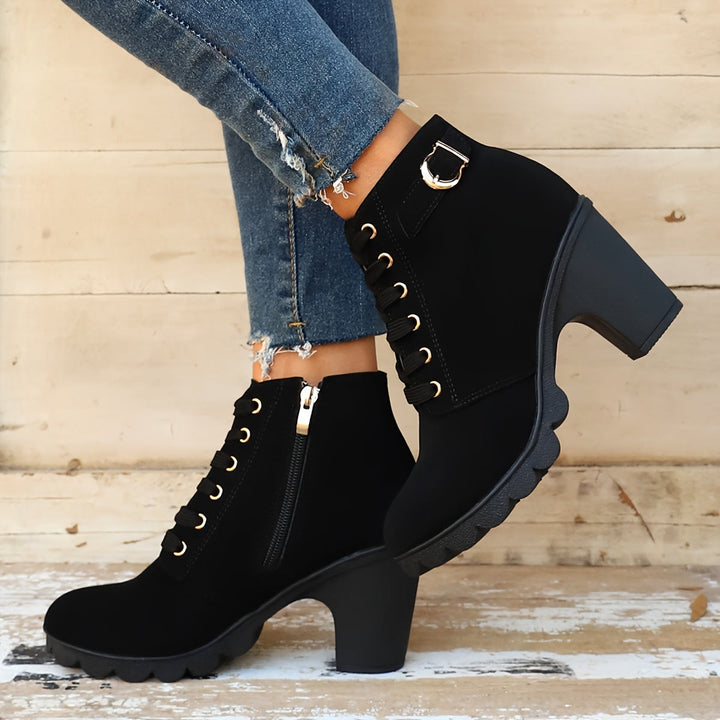 Bottines noires à talon bloc avec lacets dorés et fermetures éclair. Élégantes et confortables, idéales pour compléter un look chic et moderne.