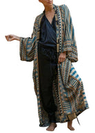 Kimono femme Bleu long et élégant, motifs rayés bleu et beige avec bordures graphiques, manches larges style kimono, porté avec une tenue noire.