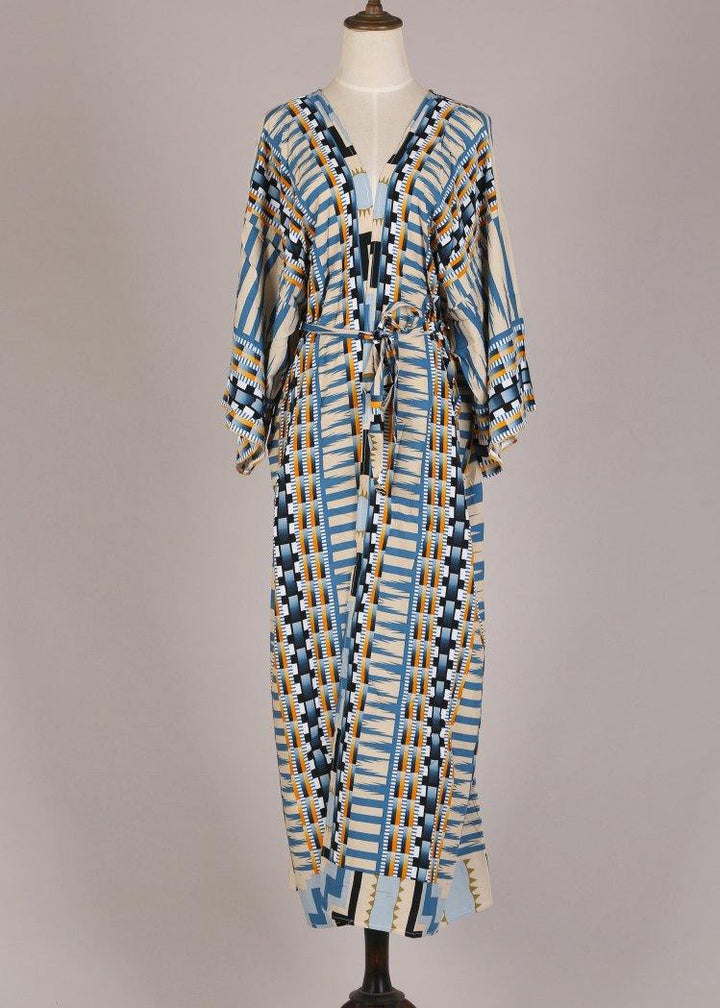 Kimono femme Bleu long et élégant sur mannequin, imprimé graphique bleu, beige et noir, manches amples et ceinture à nouer.