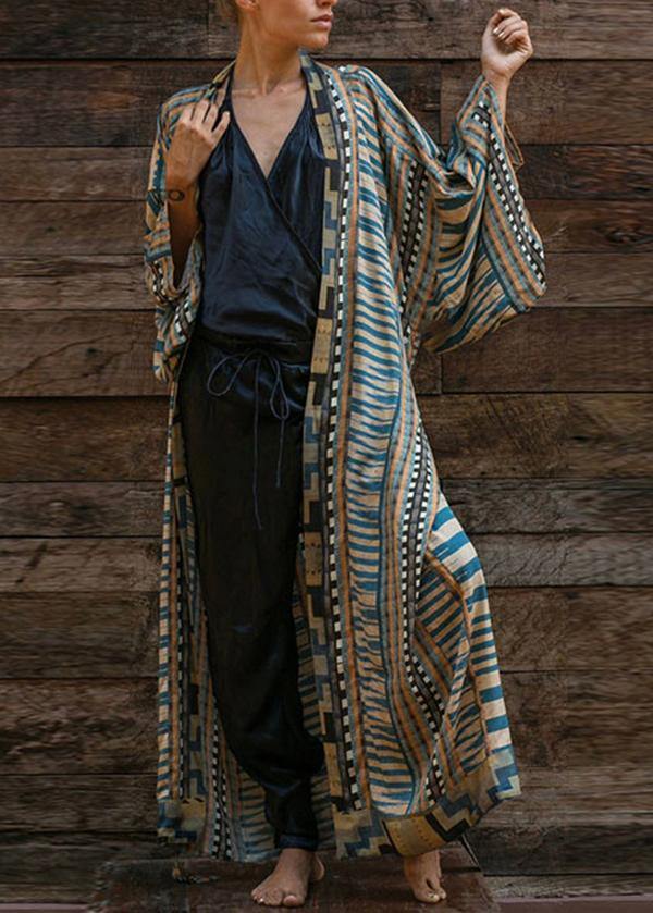 Kimono femme Bleu long et élégant, imprimé rayé bleu et beige avec bordures géométriques, manches amples, porté ouvert avec une tenue noire.