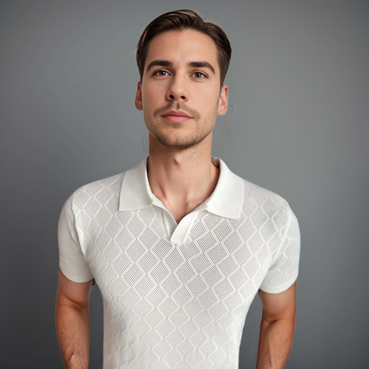 Un homme portant un polo blanc à motif en losanges, alliant élégance et confort pour un look quotidien raffiné et moderne.