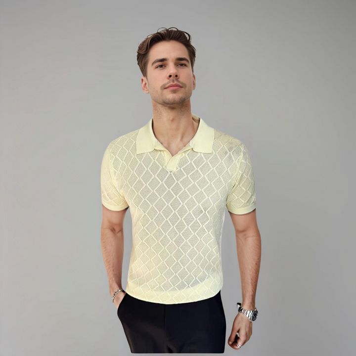 Un homme portant un polo jaune pâle à motif en losanges, avec une coupe moderne et élégante, idéal pour un look décontracté mais raffiné au quotidien.