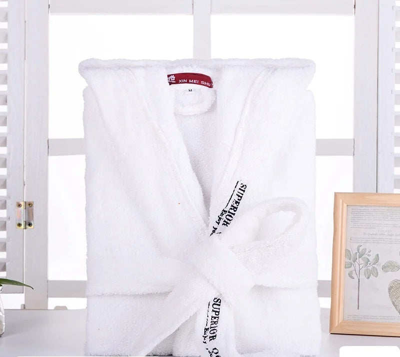 Peignoir Cédric pour homme, modèle doux et relaxant en tissu blanc, présenté plié avec sa ceinture nouée dans un décor lumineux et épuré.