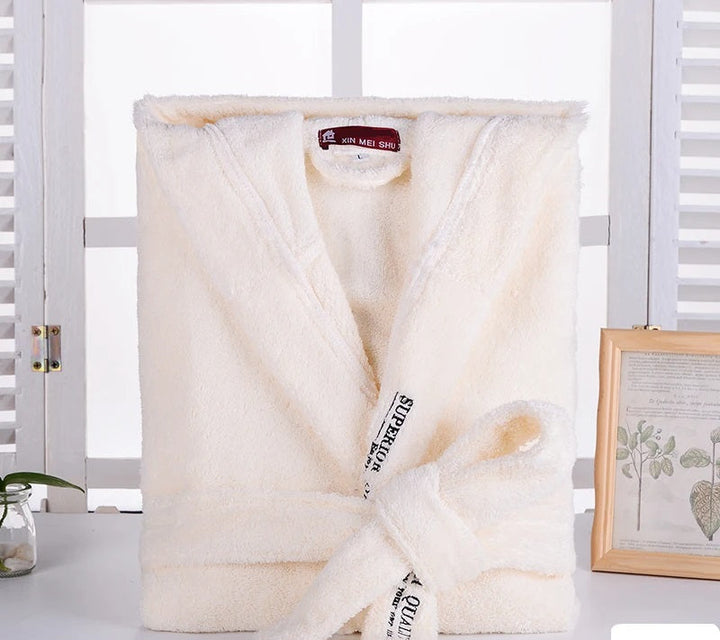 Peignoir Cédric pour homme, modèle doux et relaxant en tissu jaune pâle, présenté plié avec sa ceinture nouée sur une surface blanche dans un décor lumineux.