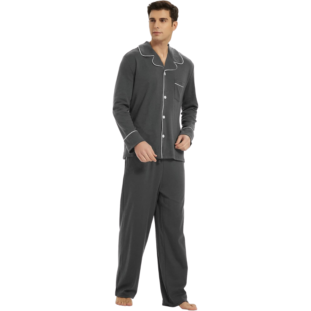Homme portant un pyjama gris anthracite composé d’un haut boutonné à col classique avec passepoils blancs et d’un pantalon long assorti. Ensemble sobre, élégant et confortable, idéal pour les nuits reposantes ou les journées à la maison.