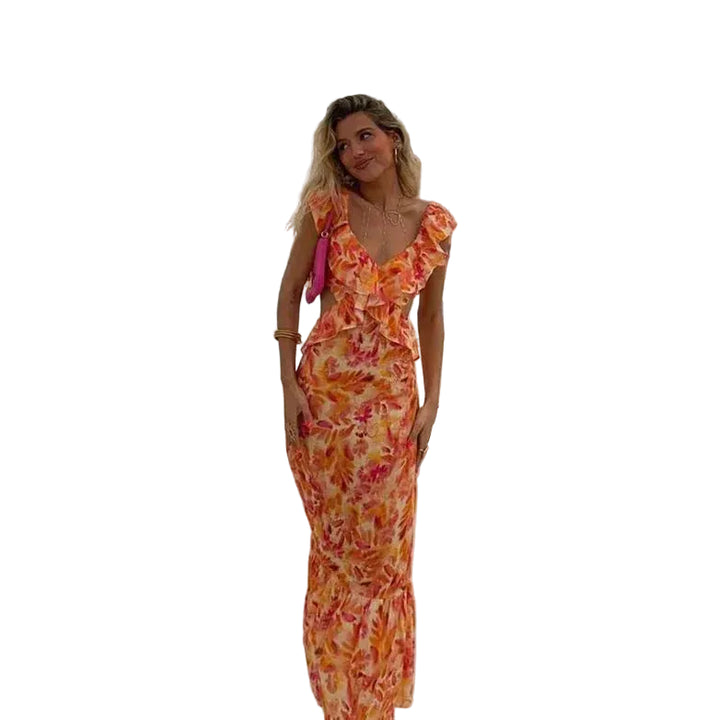 Robe maxi femme Calais fluide à imprimé floral orangé et rose avec détails volantés au décolleté, portée au bord d’une piscine pour un style élégant, féminin et estival.