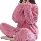 Femme portant le pyjama Camille, un ensemble douillet rose en tissu texturé effet torsadé. Parfaitement cosy, doux et agréable pour des moments de détente à la maison.