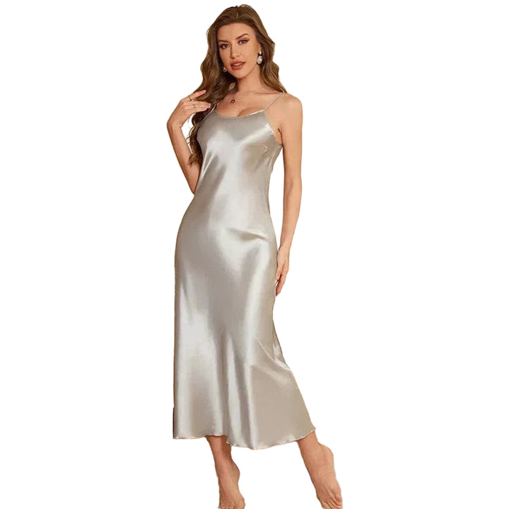Femme portant la nuisette Carine longue en satin argenté, à fines bretelles et coupe fluide. Lingerie élégante, légère et agréable à porter, parfaite pour les nuits douces ou comme tenue de détente chic à la maison.