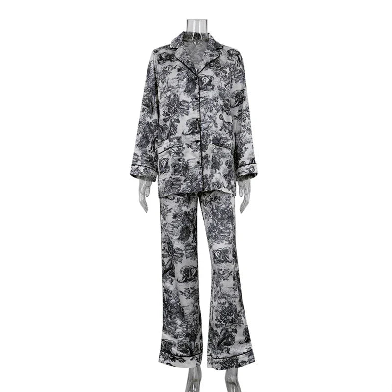 Pyjama femme Charline gris imprimé toile de Jouy, ensemble deux pièces sur mannequin avec chemise boutonnée à col tailleur et manches longues, pantalon long évasé assorti, finitions passepoilées élégantes.