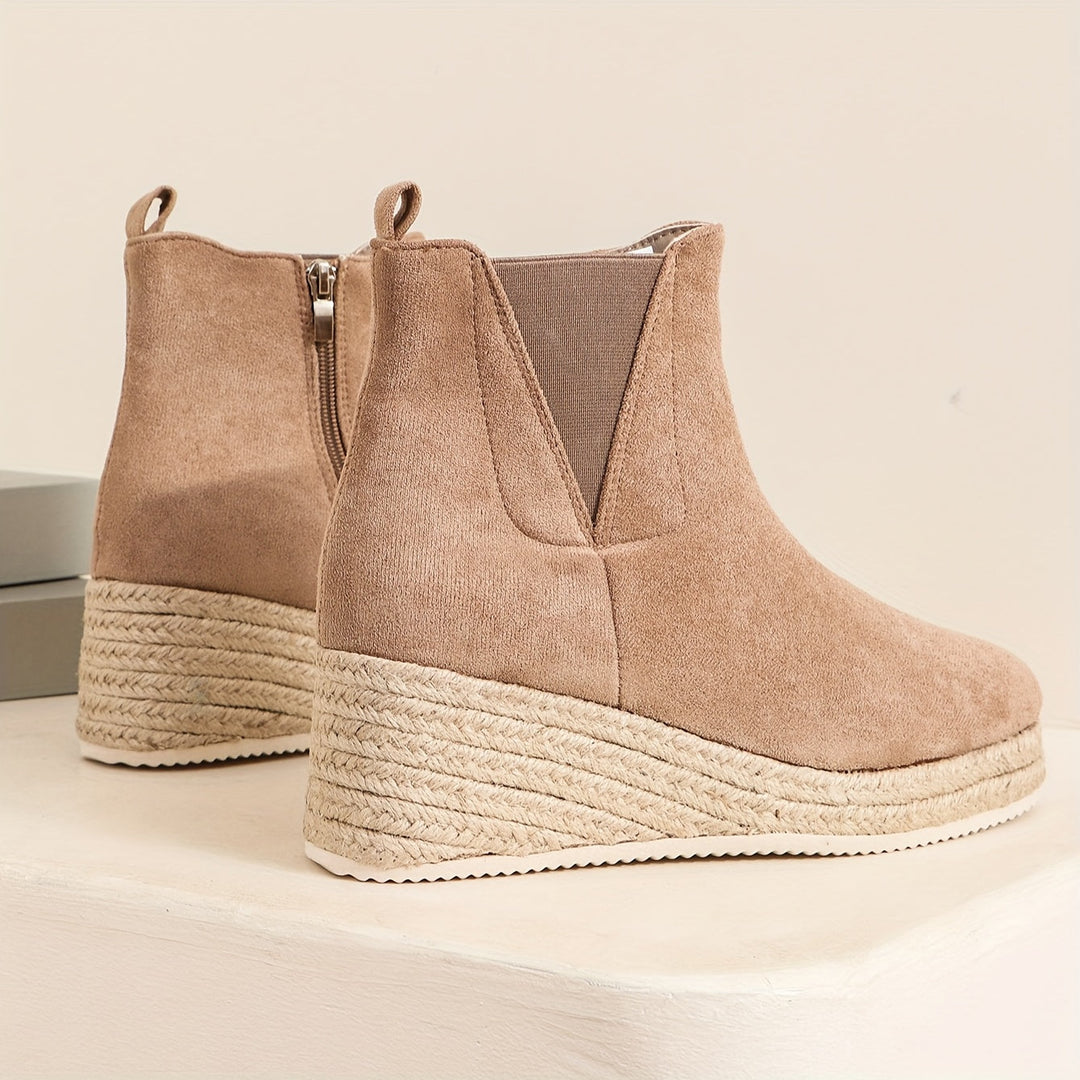 Vue arrière des bottines beige en daim avec un talon compensé en corde, avec une fermeture éclair sur le côté. Ces bottines élégantes sont dotées d&
