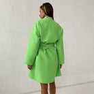 Peignoir en coton pour femme Citron vert vif, tissu gaufré, coupe mi-longue avec ceinture, porté de dos devant un mur clair.