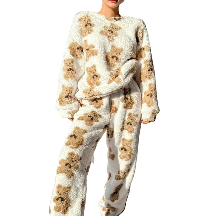 Femme portant un pyjama polaire deux pièces blanc à motif têtes d’oursons beige, composé d’un haut à manches longues et d’un pantalon assorti. Ensemble ultra doux, chaud et agréable, parfait pour les nuits d’hiver et les moments cocooning.