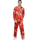 Homme portant le pyjama satin Corentin, ensemble de nuit pour homme au coloris rouge avec motifs dragon dorés, composé d’une chemise à manches longues boutonnée et d’un pantalon assorti, présenté dans un intérieur élégant.