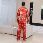 Homme vu de dos portant le pyjama en satin Corentin, ensemble homme élégant rouge à motif dragon, coupe longue avec pantalon assorti, présenté dans un intérieur moderne.