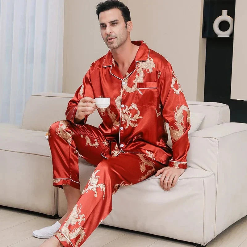 Homme portant le pyjama satin homme Corentin rouge à motif dragon doré, coupe élégante avec veste boutonnée et pantalon assorti, présenté dans un intérieur moderne.