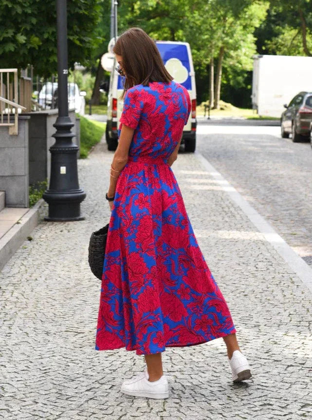 Robe midi à imprimé floral rose et bleu, cintrée à la taille avec une coupe fluide. Idéale pour les journées d&