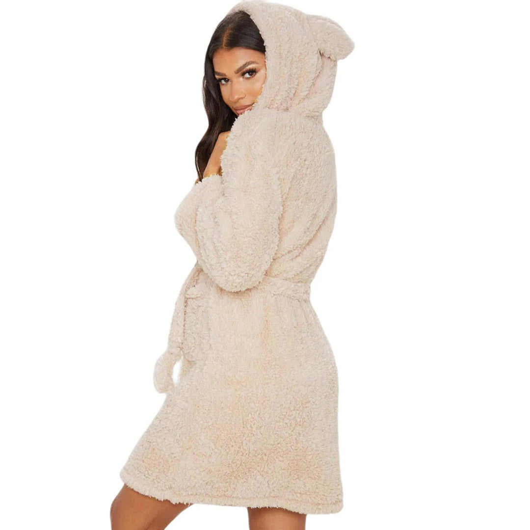 Femme portant le peignoir, un modèle beige court et ultra-doux avec capuche ornée d’oreilles. Peignoir chaud, confortable et parfait pour l’hiver, offrant un look cosy et ludique.