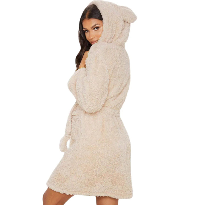 Femme portant le peignoir, un modèle beige court et ultra-doux avec capuche ornée d’oreilles. Peignoir chaud, confortable et parfait pour l’hiver, offrant un look cosy et ludique.