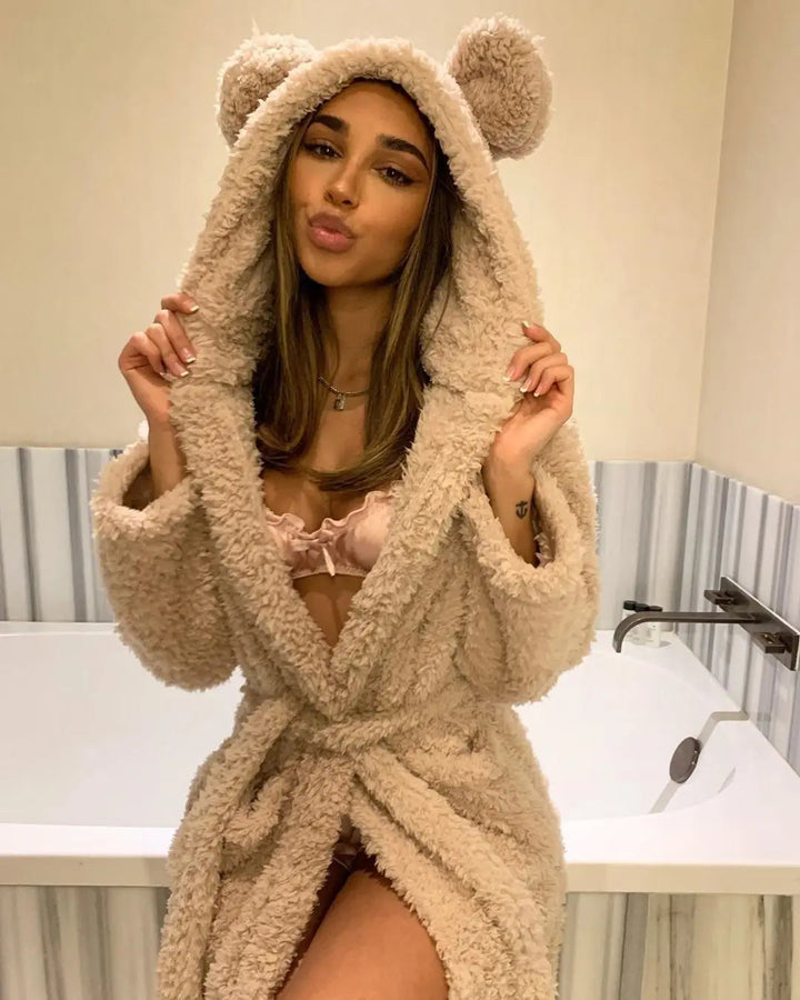 Femme portant le peignoir, un modèle beige ultra-doux avec capuche décorée d’oreilles, noué à la taille. Peignoir chaud et confortable, parfait pour l’hiver et les moments cocooning.