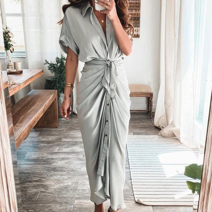 Adoptez un style chic et léger avec la robe Deja en gris clair. Son design fluide, avec un nœud central et des boutons à l&