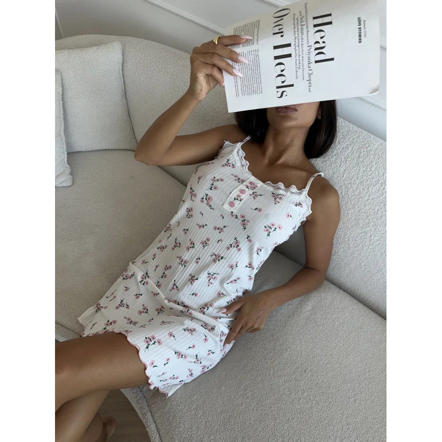 modèle en nuisette blanche à motif fleuri, fines bretelles et bordure dentelée, portée allongée sur un canapé avec un magazine.