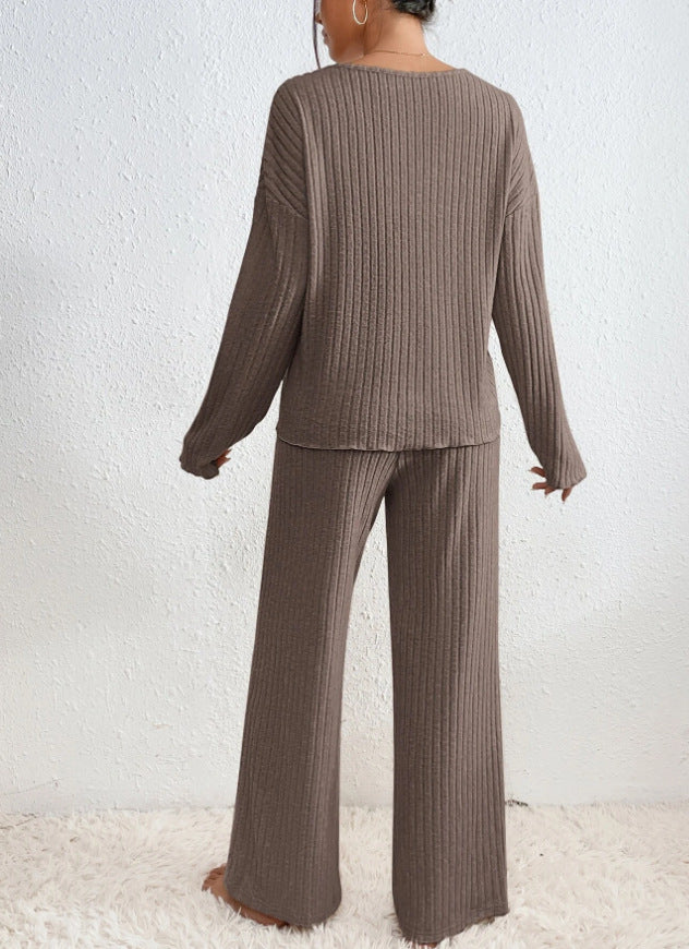 Vue arrière de l’ensemble Diane en tricot côtelé marron chocolat, porté par une femme debout pieds nus sur un tapis moelleux. Ensemble d&