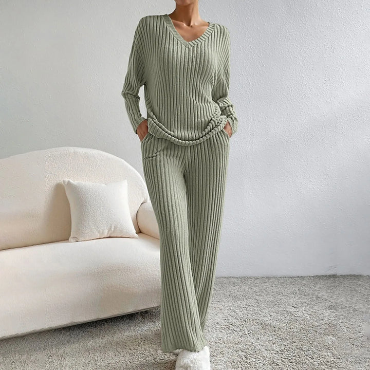 Ensemble vert sauge en maille côtelée, composé d’un haut à col en V et manches longues, assorti d’un pantalon fluide avec poches. Une tenue loungewear parfaite pour allier confort et raffinement à la maison.