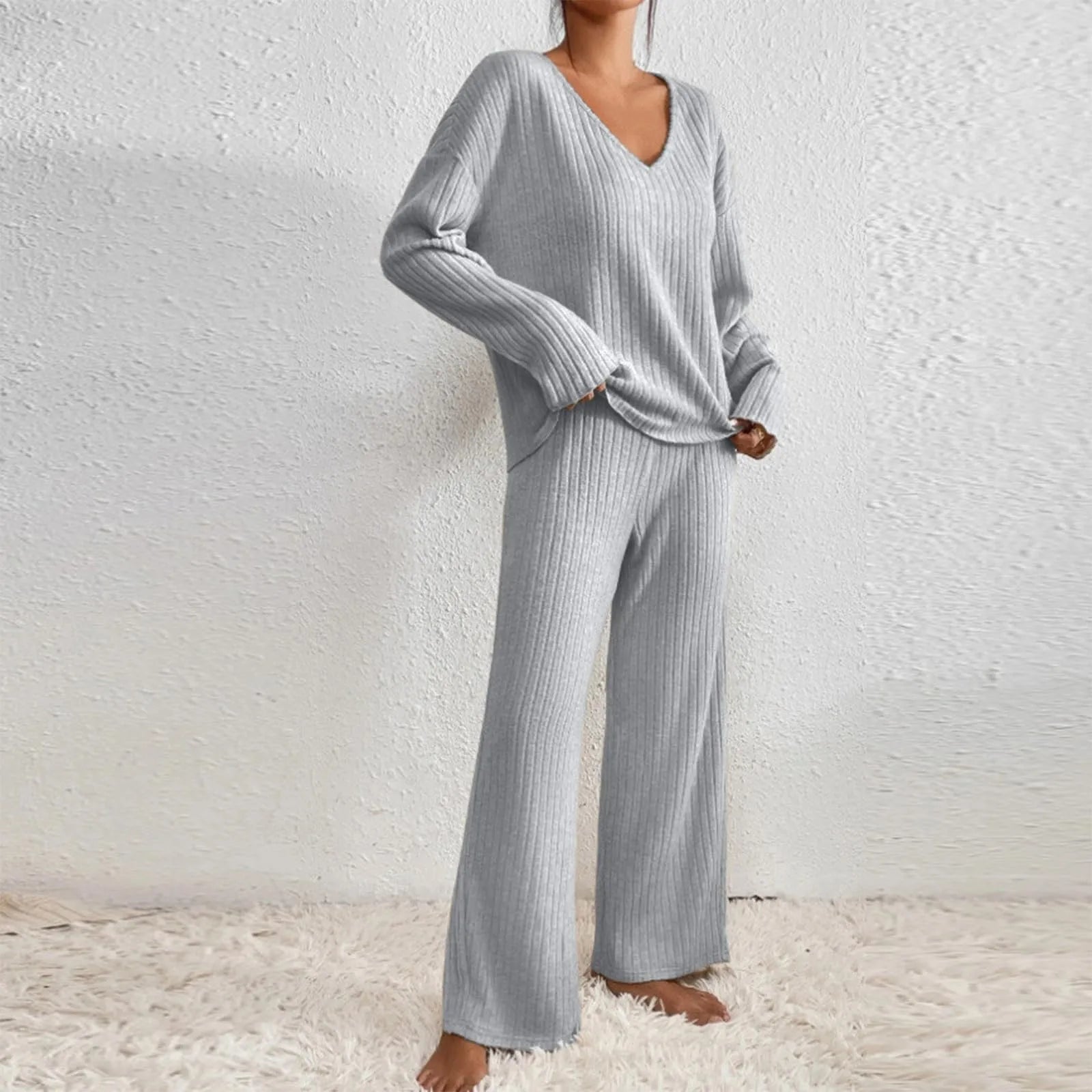 Ensemble d’intérieur gris clair pour femme en maille côtelée, composé d’un haut à col en V manches longues et d’un pantalon ample. Confort et style pour vos moments de détente à la maison.