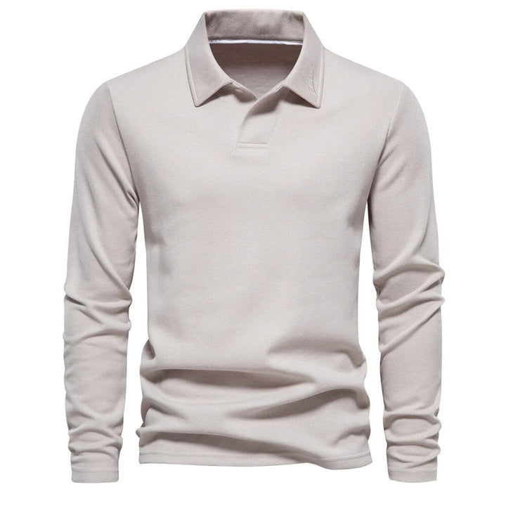 Polo beige à manches longues pour homme avec un col classique. Ce modèle élégant et confortable est idéal pour une tenue décontractée mais raffinée, apportant un style intemporel et moderne.