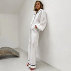 Pyjama femme Édith blanc, ensemble raffiné et agréable avec chemise à manches longues et pantalon large assorti, détails noirs sur le col et les jambes, style élégant et confortable, parfait pour un look détendu mais chic.