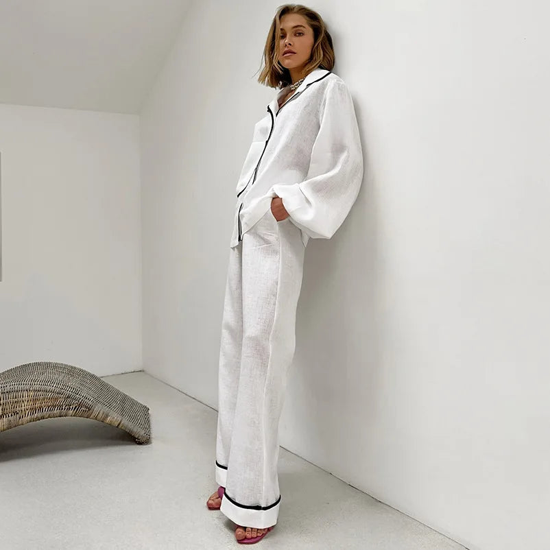 Pyjama femme Édith blanc, ensemble raffiné et agréable avec chemise à manches longues et pantalon large assorti, détails noirs sur le col et les jambes, style élégant et confortable, parfait pour un look détendu mais chic.