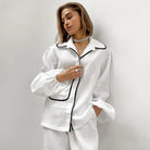 Pyjama femme Édith blanc, chemise à manches longues avec col classique et finitions noires, coupe élégante et confortable, avec pantalon assorti, un ensemble raffiné pour des moments de détente stylés.